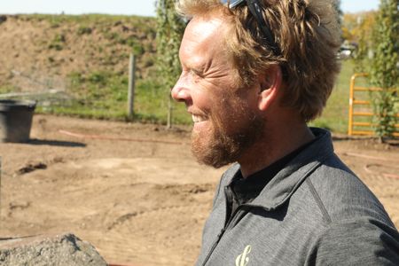 Ben Reinhold smiles while working on the Pol family farm's new garden and pond. (National Geographic)