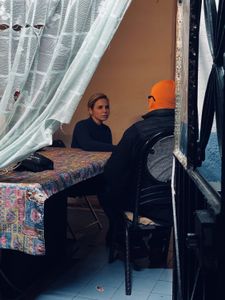 Mariana van Zeller interviews "Señor T" and "Amarillo," members of a gang involved in the fake pill trade, at a safe house in Mexico City. (National Geographic for Disney)