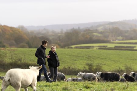 Antoni Porowski and Florence Pugh walk through a field in Yorkshire. (National Geographic/Chris Raphael)