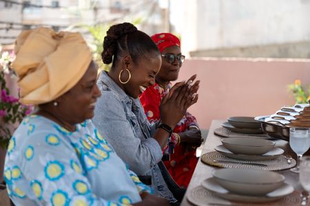 Aissa Diop, Issa Rae and Marie Diop wait for the Soupe Kanja to be served. (National Geographic/John Wendle)