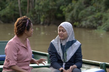 Paula Kahumbu speaks with Farina Othman about the work Farina's project is doing to help protect elephants from entering palm oil plantations. (National Geographic for Disney/Cede Prudente)