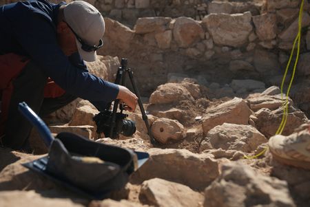 In this behind-the-scenes photo, crew member Andrew Richens takes a close-up photo of the fresh find at the dig site in Amman, Jordan. (Windfall Films/Alex Collinge)