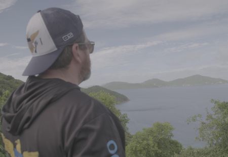 A CBP Agent stands at a look out point on top of mountain, gazing at the ocean in St Thomas, USVI. (Lucky 8 TV)