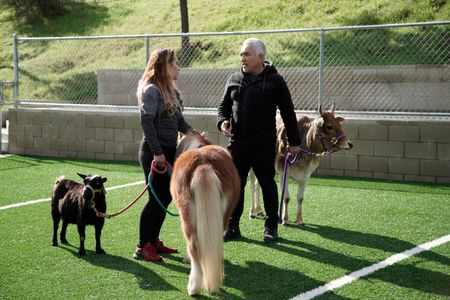 Jen and Cesar chat while holding Dog Psychology Center animals. (National Geographic)