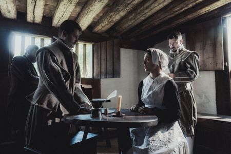 Geillis Duncan sits in pensive thought as David Seton interrogates her for witchcraft. Members of the gentry examine paperwork and listen to the interrogation. (Dash Productions Services LTD/Antoan Ivanov)