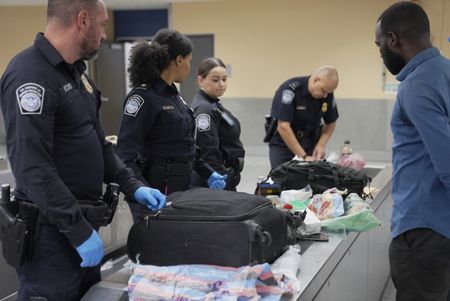 CBP Officers Evans, Laska, Mccants and Supervisory Officer Pacheco question a passenger while going through their belongings in Atlanta, Ga. (National Geographic)