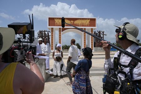 Clotilda descendants and National Geographic Explorer and Storyteller Tara Roberts speak in front of The Door of No Return on Ouidah Beach, where many captured Africans were forcibly marched through before boarding slave ships to the New World. (National Geographic/Etinosa Yvonne)