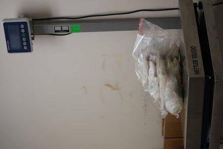 Multiple packages of suspected narcotics are placed on a scale to be weighed after they were found smuggled in a suspect's vehicle in Calexico, Calif. (National Geographic)