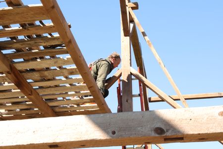 Ben Reinhold carefully removes the beams from the old barn they are taking down to transport and restore on the Pol family's farmland. (National Geographic)