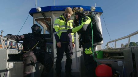 Men on a boat in scuba outfits. (National Geographic)