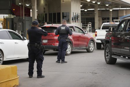 CBP officers look on as multiple vehicles wait in line to cross at the El Paso border in El Paso, Texas. (National Geographic)