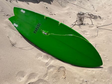 Jason Lammers green surfboard that had been damaged by the shark. (National Geographic/Robert Cowling)