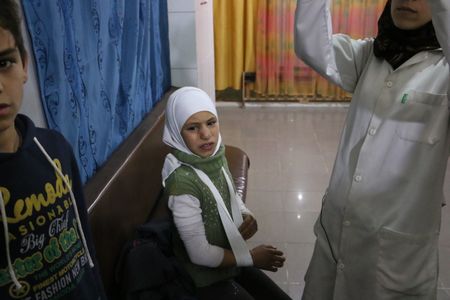 Al Ghouta, Syria - Injured girl (center) in the hospital after treatment. (National Geographic)