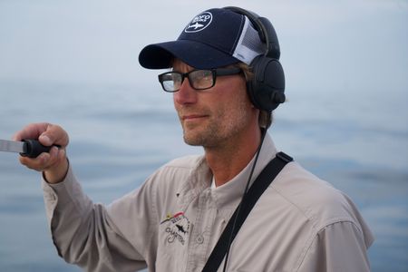 Capt. Greg Metzger stands looking out to sea, while using a VHF receiver as the team desperately try to get a signal from Liberty's tag. (National Geographic/Brandon Sargeant)
