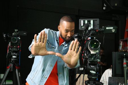 Keon Poole pretending to be frame a shot next to video equipment. (National Geographic/Robert Toth)