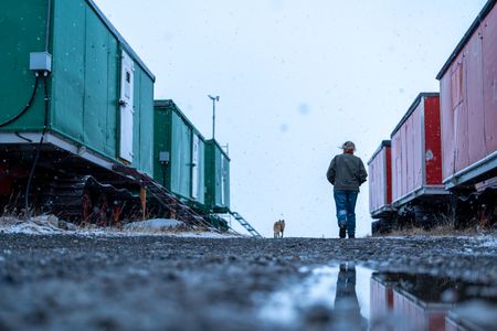 Sue Aikens checks Kavik River Camp along with a fox companion. (BBC Studios Reality Productions/Jayce Kolinski)