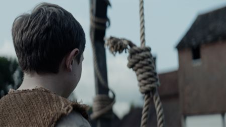 A young village boy looking at the noose used to hang witches. (Dash Productions Services LTD/Samuel Purcell, Oliver Watts)