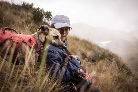 National Geographic Explorer Ruthmery Pillco Huarcaya takes a break with her dog, Ukuku. Ukuku's role is to find bear feces so Ruthmery can study their diet. (credit: National Geographic/Pablo Durana)