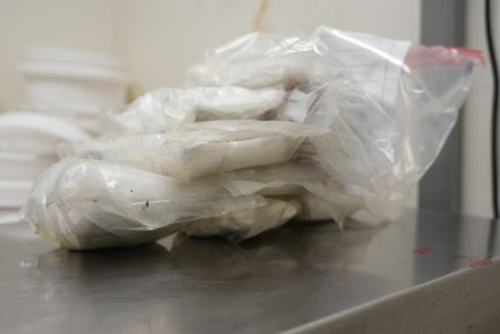 Multiple packages of suspected narcotics are placed on a scale to be weighed after they were found smuggled in a suspect's vehicle in Calexico, Calif. (National Geographic)