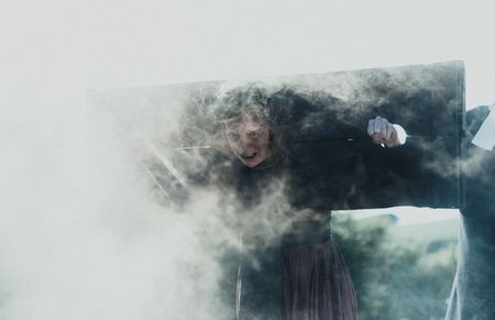 An accused witch stands locked in a pillory, shrouded by smoke. (Dash Productions Services LTD/Antoan Ivanov)