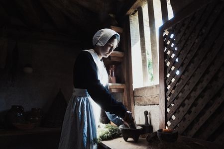 Geillis Duncan muddles plants and herbs for medicinal properties inside her home. (Dash Productions Services LTD/Antoan Ivanov)