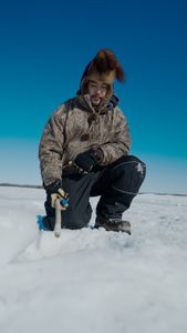 Gage Hoffman ice fishing in freezing temperatures. (BBC Studios Reality Productions, LLC/Brian Bitterfeld)