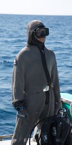 A diver wearing a suit and holding tanks. (Big Wave Productions)