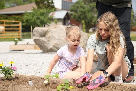 Abigail Pol and Brooklyn Reinhold plant seeds in the new garden at the Pol family's farm. (National Geographic)