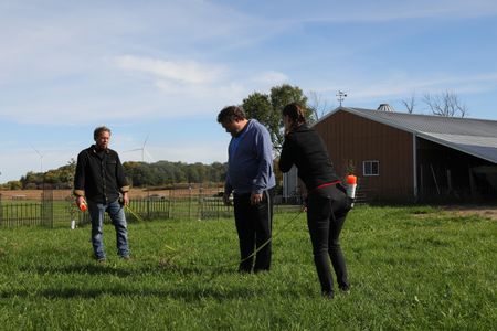 Ben Reinhold, Charles Pol, and Beth Pol use a tape measure and spray paint to plan out the Pol family farm's new garden. (National Geographic)