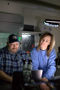 Dr. Tobey Curtis and Dr. Megan Winton stand smiling while looking at the data retrieved from Liberty's tag at the School for Marine Science and Technology in New Bedford, MA. (National Geographic/Zara Tyne)