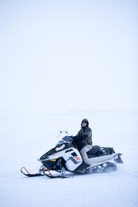 Qutan Hailstone hunts caribou while traveling on snowmobile through the icy tundra. (BBC Studios Reality Productions, LLC/Ashton Hurlburt)