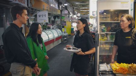 Antoni Porowski, Awkwafina, Jain Song and Sonmat eat at the Kimbap stall at Tongin Market. (National Geographic)