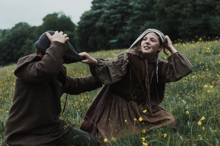 Gertrude, a young girl, tugs on the woolen cap of Mats, her young companion. (Dash Productions Services LTD/Antoan Ivanov)