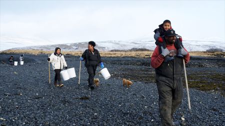 The Amodo-White family collect clams to add to their community garden. (National Geographic)