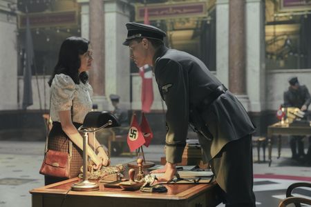A SMALL LIGHT - Miep Gies, played by Bel Powley, approaches Silberbauer, played by Daniel Donskoy, at the Gestapo Headquarters as seen in A SMALL LIGHT. (Credit: National Geographic for Disney/Dusan Martincek)