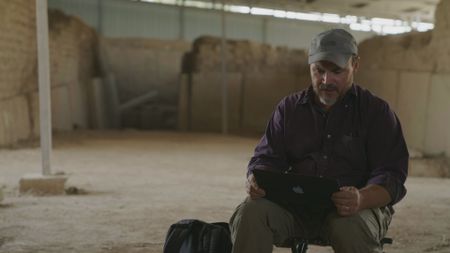 Michael Danti examines Assyrian sculptures found at the Mashki Gate in Mosul, Iraq. (Windfall Films/Ali Hilal Ali Hussain)