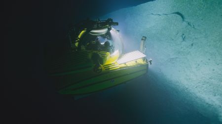 One of the OceanXplorers submersibles gradually makes its way up a pinnacle, as the team explores every crack for signs of migrating sharks. (National Geographic)
