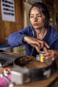 National Geographic Explorer Ruthmery Pillco Huarcaya checks the data from a GPS collar that was recovered from an Andean bear. (credit: National Geographic/Pablo Durana)