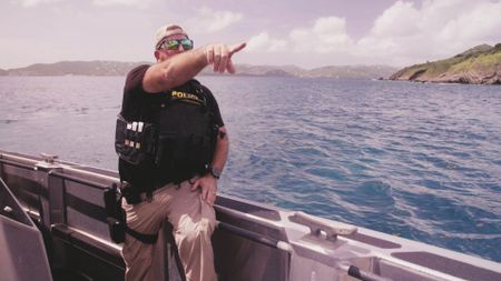 CBP AMO Agent Jeff points to a spot on land where he thinks he sees a bale of drugs. (Lucky 8 TV/Sharon Manente)