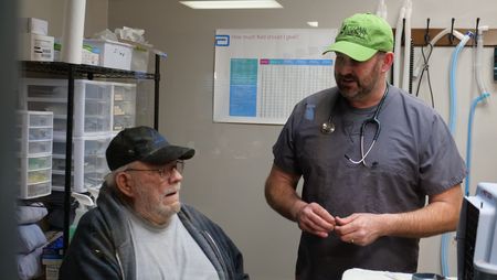 Owner Jesse Robinett talks with Dr. Ben Schroeder about his cat Tomcat, who has been suffering from severe tremors brought on by hyperthyroidism. (National Geographic)