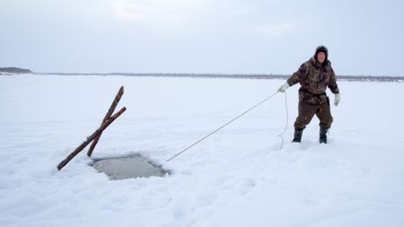 Chip Hailstone pulls the a fish net through the ice. (BBC Studios/Dwayne Fowler)