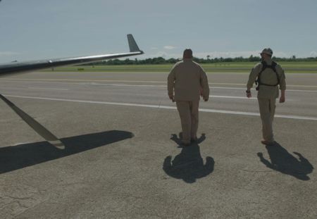 Two CBP Agents walk on an airport runway next to an aircraft in Mayaguez, PR. (Lucky 8 TV)