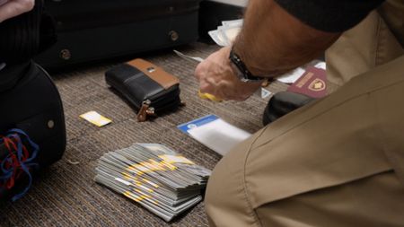 A CBP officer examines flower bouquets found in a shipment for agriculture violations in Miami.(National Geographic)