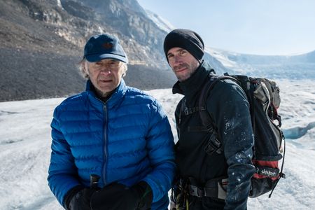 Joseph and Ranulph Fiennes stand on the Athabasca Glacier.  Sir Ranulph Fiennes, "the greatest living explorer," and his cousin, actor Joseph Fiennes, revisit Ran’s 1971 expedition of Canada’s British Columbia.