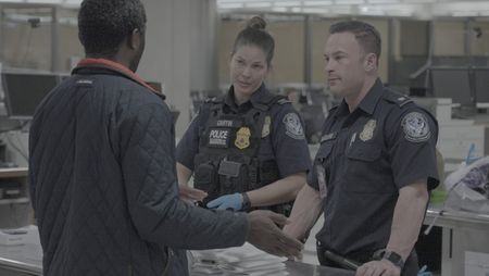 Chief Augustino and CBP Officer Griffin question a courier about the numerous electronic devices found in their belongings in Dulles, Va. (National Geographic)