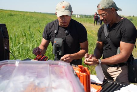 Researcher José R. Ramìrez-Garofalo prepares to band a grasshopper sparrow held by Christian Cooper at Freshkills Park. (National Geographic/Troy Christopher)