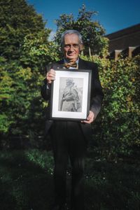 Expert consultant Dr. Ghee Bowman holds a portrait of Siddiq Ahmed outside his home in Exeter, England. Medic Siddiq Ahmed was a member of Force K6, an Indian Regiment of mule handlers in WW2. Amidst the chaos of Dunkirk and the advancing German Army, one little-known Indian Regiment fights for victory and independence. (National Geographic/Daniel Dewsbury)