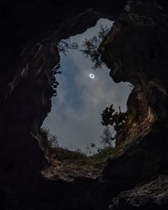 A total eclipse of the sun is seen through one of mouths of Frio Cave in Uvalde County, Texas on April 8, 2024. (Babak Tafreshi/National Geographic)