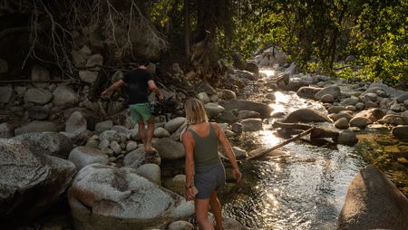 Cinematographer Nick Kraus and Angel Collinson walk down a creek.  (National Geographic/Elena Gaby)