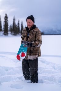 Johnny Rolfe uses an auger to cut through the ice and set his burbot lines. (BBC Studios Reality Productions/Patrick Henderson)